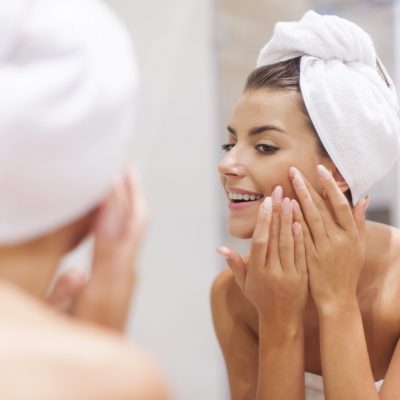 Woman removing pimple from her face