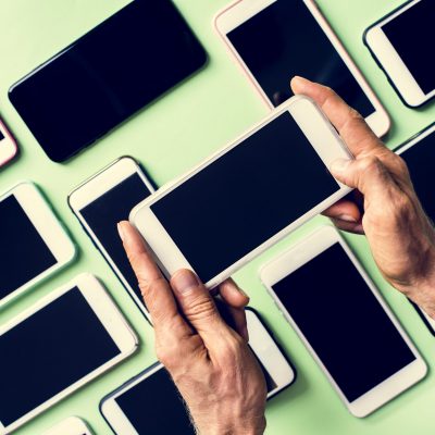 Hands holding smartphone with smartphone on background