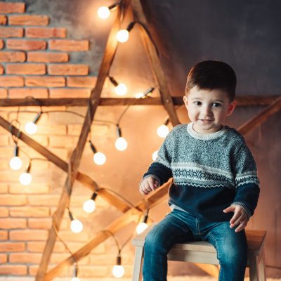 little boy sitting on a chair and looking at the camera