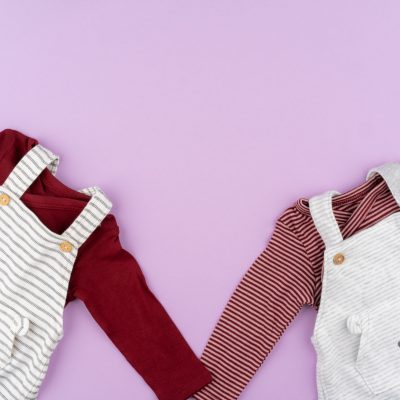Baby girl clothes on lilac pastel background
