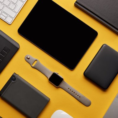 flat lay with different wireless devices on yellow surface