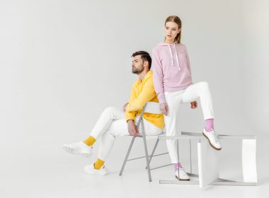 young male and female models in pink and yellow hoodies on white